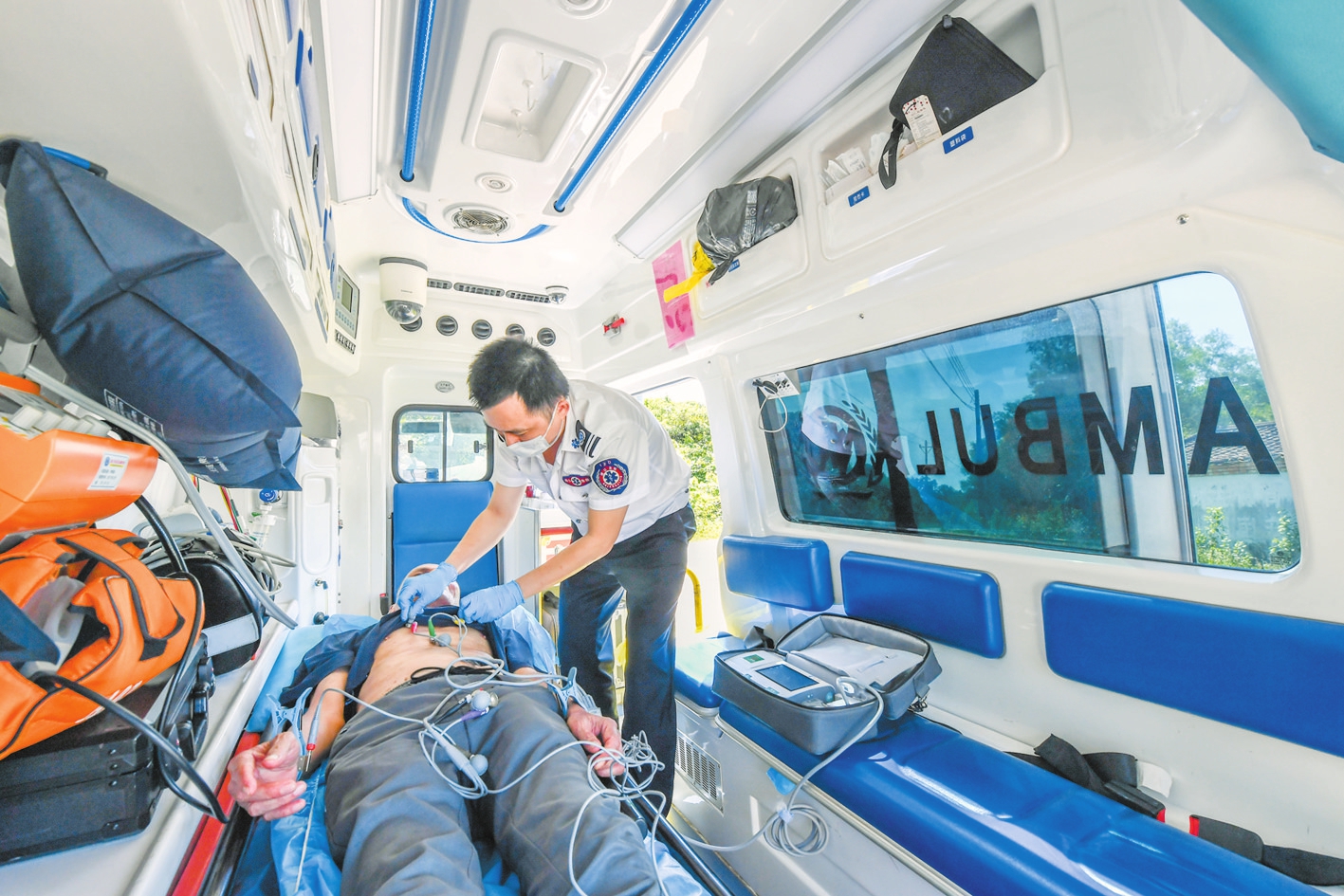 一名甲子镇的胸痛患者在120救护车上接受院前急救.