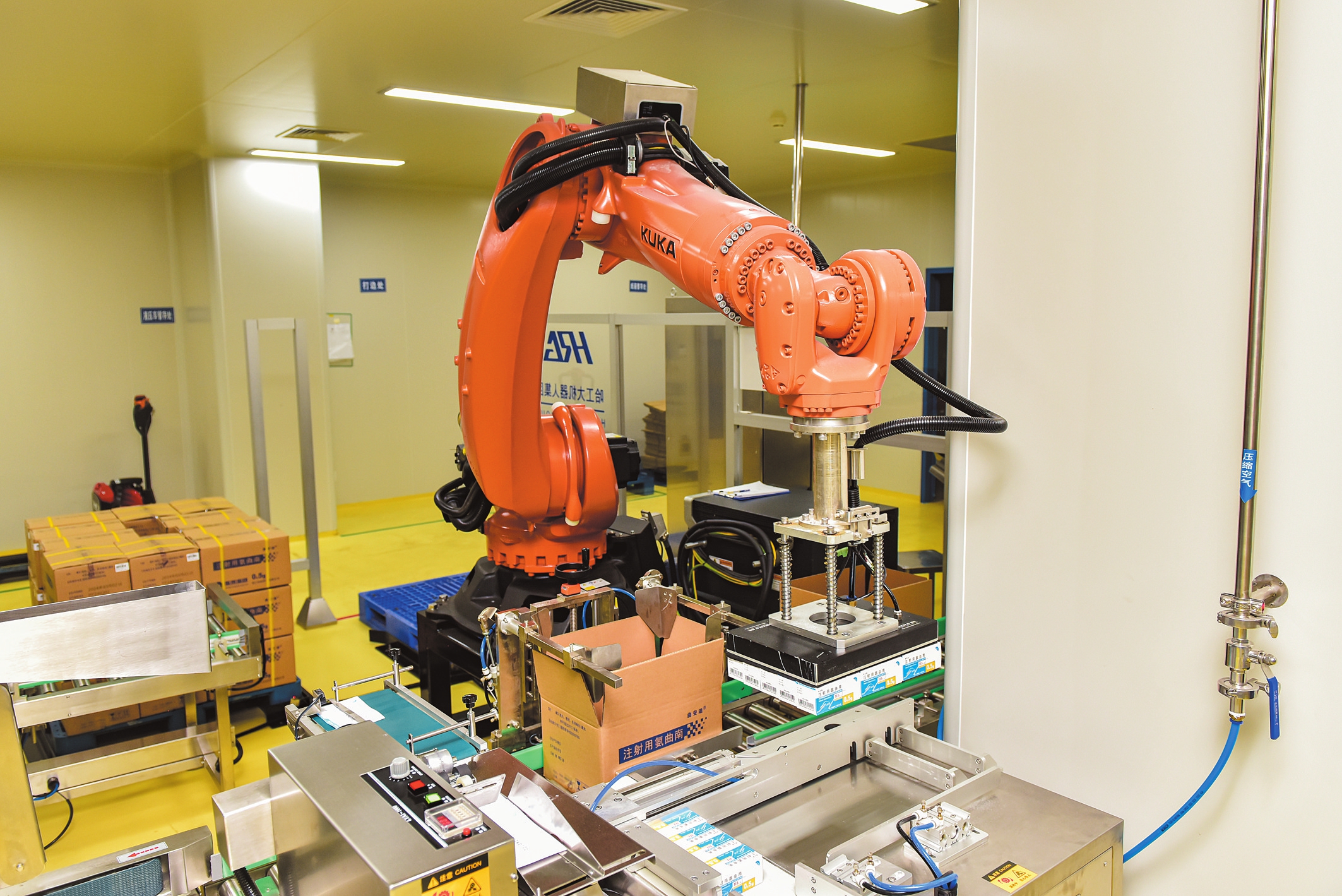 在新兴际华海药普通粉针车间,机器人自动打包药品.